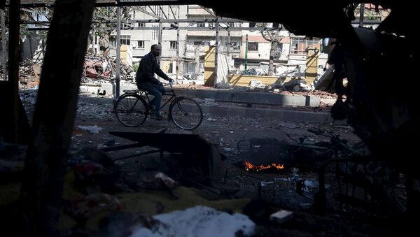 Un hombre en bicicleta en Douma, un barrio a las afueras de Damasco - Sputnik Mundo