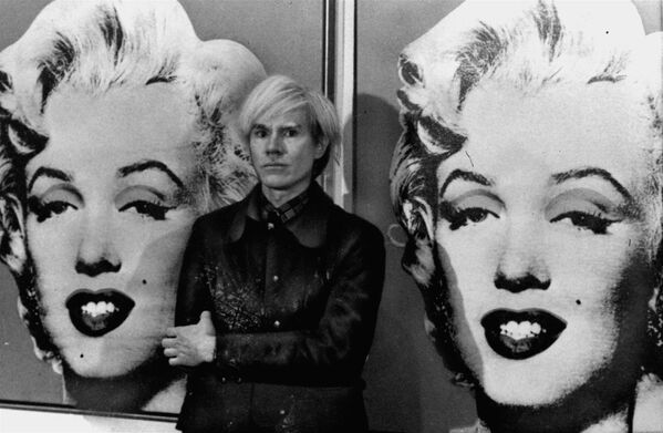 America's pop art painter and filmmaker, Andy Warhol, stands in front of his double portrait of the late Hollywood film star, Marilyn Monroe, at The Tate Gallery in London, February 15, 1971, at a press preview of his exhibition.  - Sputnik Mundo