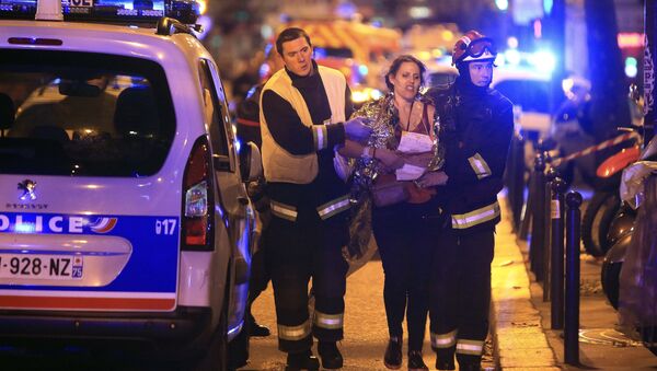 Socorristas ayudan a una mujer tras tiroteo en la sala de Bataclan en París - Sputnik Mundo