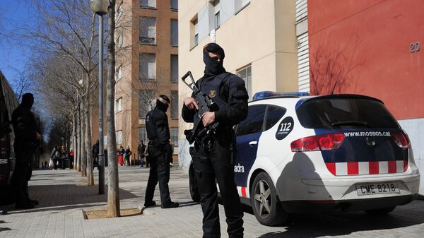 Mossos d'Esquadra regional police officers stand guard during a raid in one of the region's biggest operations against jihad activity in Sabadell, near Barcelona, Spain, Wednesday, April 8, 2015 - Sputnik Mundo
