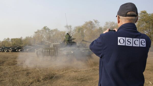Un observador de la OSCE registra la retirada de tanques en la localidad de Stajanov, bajo control de las fuerzas de la RPL. 20 de octubre de 2015 - Sputnik Mundo