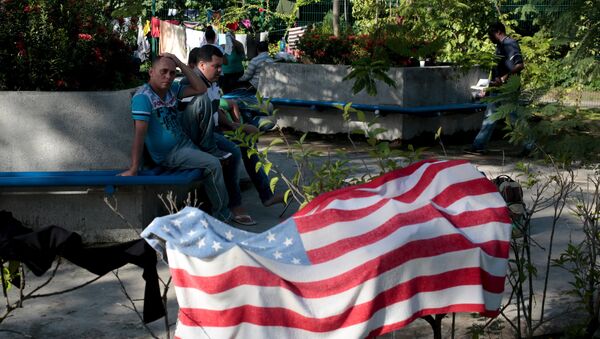 Migrantes cubanos cerca una toalla con la bandera de EEUU en Peñas Blancas, Costa Rica - Sputnik Mundo