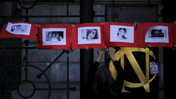 Fotos de las víctimas de femicidio en Argentina durante una manifestación en el Día Internacional contra la Violencia de Género - Sputnik Mundo