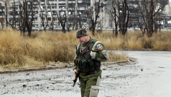 Un miliciano cerca de los edificios destruidos en Donetsk - Sputnik Mundo