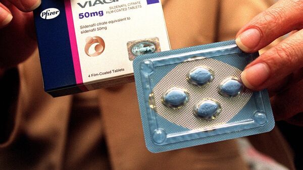 A public relation staff shows Viagra pills at a press conference in Singapore 19 April 1999 - Sputnik Mundo