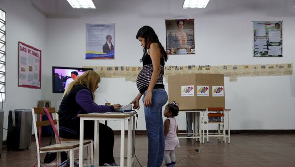 Una mujer vota en las elecciones parlamentarias en Caracas, Venezuela - Sputnik Mundo