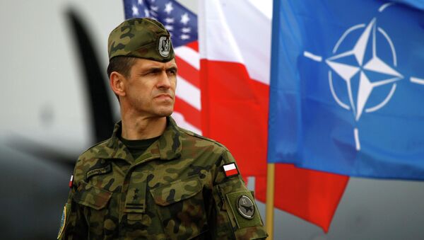 Soldado polaco cerca de banderas de Polonia, OTAN y EEUU - Sputnik Mundo