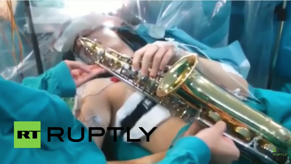 Paciente toca el saxofón durante una cirugía cerebral - Sputnik Mundo