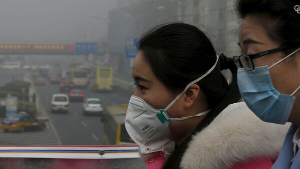 Woman wearing protective masks walk on a heavily polluted day in Beijing, December 25, 2015. - Sputnik Mundo