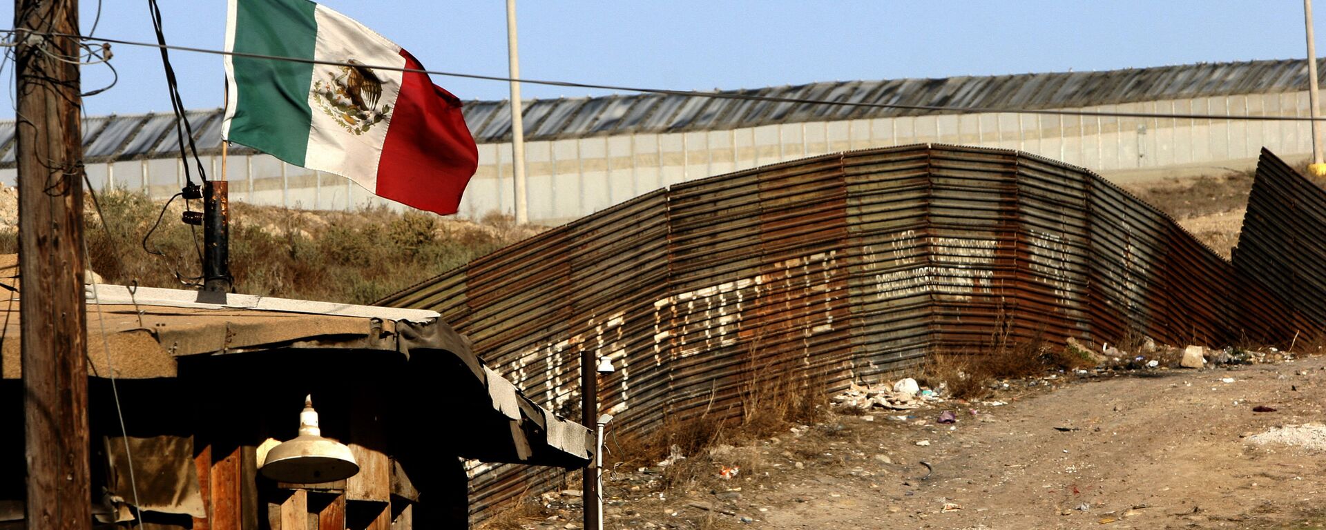 A Mexican flag waves close to the wall which separates Mexico from the United States 24 January 2006, in Tijuana, state of Baja California - Sputnik Mundo, 1920, 02.02.2022