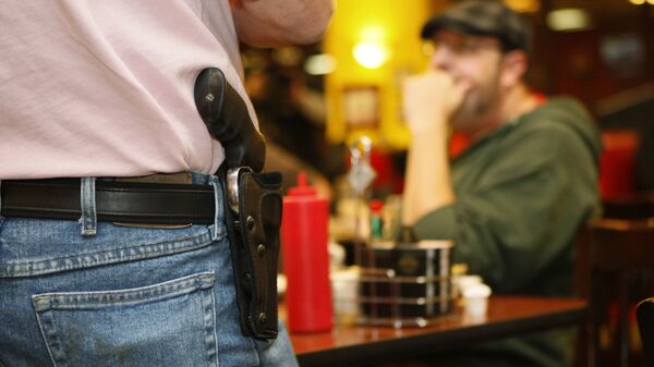 Bryan Hull, founding director of the Oklahoma Open Carry Association (OKOCA), wears an unconcealed side arm as he addresses OKOCA members gathered at Beverly's Pancake House in Oklahoma City in this file photo from November 1, 2012 - Sputnik Mundo