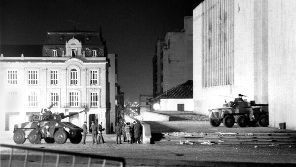 Colombian army officers standing near armored cars talk about their next move after a half dozen of the armored cars hammered the Palace of Justice for an hour Thursday morning with cannon and machine gun fire in Bogota, Colombia, Nov. 7, 1985. - Sputnik Mundo