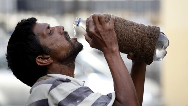 Un hombre indio bebe agua - Sputnik Mundo