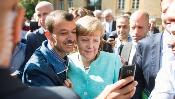 Un refugiado se hace un selfie con Angela Merkel (archivo) - Sputnik Mundo