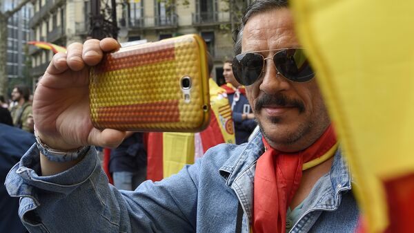 Un hombre con la bandera nacional de España durante el Día de la Hispanidad en Barcelona, Cataluña - Sputnik Mundo