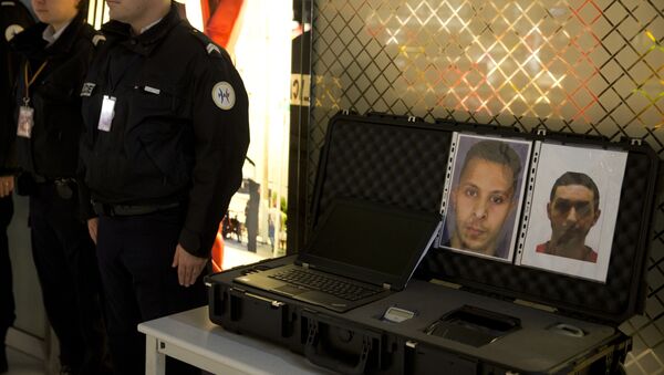 Los agentes de policía están cerca de los retratos de los terroristas Salah Abdeslam y Mohamed Abrini - Sputnik Mundo