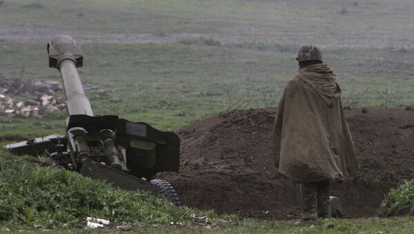Un soldado de la autodefensa de Nagorno Karabaj cerca de un cañón de artillería - Sputnik Mundo