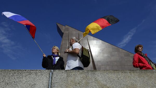 Los ciudadanos sosteniendo las banderas de Rusia y Alemania en Berlín  - Sputnik Mundo