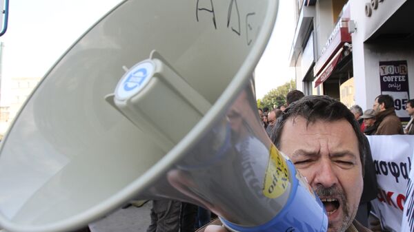 A trade union protester shouts slogans as the word ''ADEDY (Public Sector Union) is written on a loudspeaker during a protest outside a pension fund office on Tuesday, March 6, 2012 - Sputnik Mundo