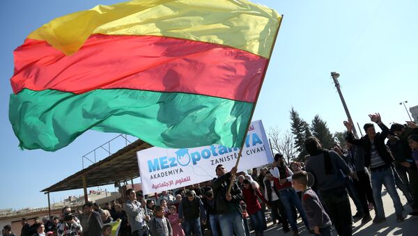 A Kurdish man waves a large flag of the Kurdish People's Protection Units (YPG) political wing, the Democratic Union Party (PYD), during a demonstration against the exclusion of Syrian-Kurds from the Geneva talks in the northeastern Syrian city of Qamishli on February 4, 2016 - Sputnik Mundo