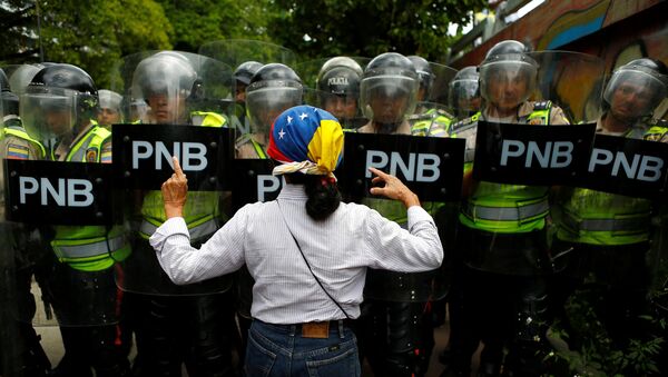 An opposition supporter argues with riot policemen during a rally to demand a referendum to remove President Nicolas Maduro in Caracas, Venezuela, June 7, 2016.  - Sputnik Mundo