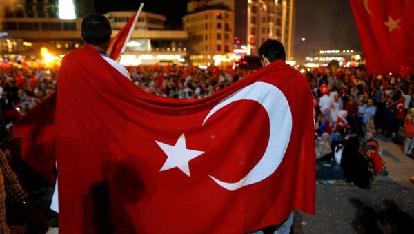 Supporters of Turkish President Tayyip Erdogan are covered with a Turkish national flag during a pro-government demonstration on Taksim square in Istanbul - Sputnik Mundo