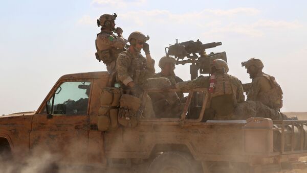 Armed men in uniform identified by Syrian Democratic forces as US special operations forces ride in the back of a pickup truck in the village of Fatisah in the northern Syrian province of Raqa on May 25, 2016 - Sputnik Mundo