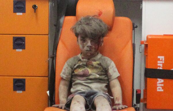 Omran Daqneesh, de cinco años de edad que con su rostro ensangrentado se convirtió en la imagen de la guerra a mano de los medios estadounidenses, se encuentra dentro de una ambulancia después de que fuera rescatado tras un ataque en la zona controlada por los insurgentes, 17 de agosto de 2016 Omran Daqneesh, de cinco años de edad que con su rostro ensangrentado se convirtió en la imagen de la guerra a mano de los medios estadounidenses, se encuentra dentro de una ambulancia después de que fuera rescatado tras un ataque en la zona controlada por los insurgentes, 17 de agosto de 2016 - Sputnik Mundo