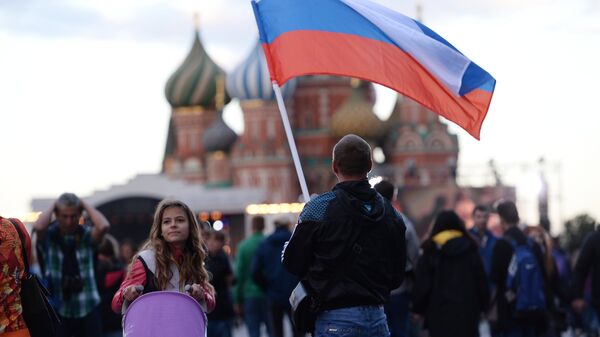 Un hombre con la bandera de Rusia en la Plaza Roja de Moscú - Sputnik Mundo