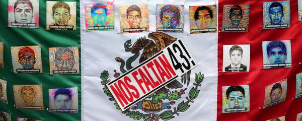 A Mexican flag and some pictures of the 43 missing students is seen in a march to demand justice for the 43 missing students of Ayotzinapa College Raul Isidro Burgos to mark the two-year anniversary of their disappearance in the state of Guerrero, in Mexico City, Mexico, September 26, 2016. A Mexican flag and some pictures of the 43 missing students is seen in a march to demand justice for the 43 missing students of Ayotzinapa College Raul Isidro Burgos to mark the two-year anniversary of their disappearance in the state of Guerrero, in Mexico City, Mexico, September 26, 2016. - Sputnik Mundo