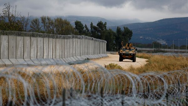An armoured military vehicle drives past a wall along the border between Turkey and Syria, near the southeastern village of Besarslan, in Hatay province, Turkey, November 1, 2016 - Sputnik Mundo
