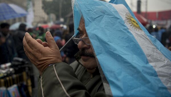 A man covered with an Argentinian flag takes part in a demonstration takes part in a demonstration of Argentine Central Workers (CTA) in front of Casa Rosada at Plaza de Mayo square, against President Mauricio Macri and economy measures in Buenos Aires on June 2, 2016. - Sputnik Mundo