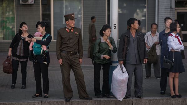 La gente esperando el autobús en una parada de Pyongyang, Corea del Norte - Sputnik Mundo
