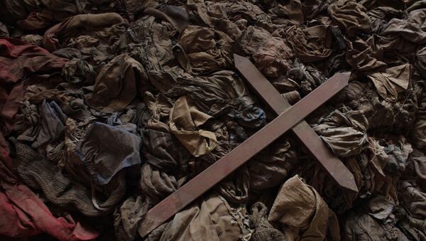 a wooden cross lies among clothes from some of the estimated 10,000 Tutsis killed in a two-day massacre at Nyamata church, now a memorial to the 1994 genocide, in the town of Nyamata, 30 kilometers outside Kigali, Rwanda. Callixte Mbarushimana is on Interpol's Wanted List for the crime of genocide in his native Rwanda where he is accused of having planned and executed the slaughter of his U.N. colleagues. Fifteen years on, he lives freely in France, as do dozens of other men accused of having plotted the murder of Rwanda's Tutsi minority. - Sputnik Mundo