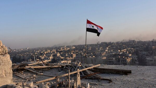 A Syrian national flag flutters near a general view of eastern Aleppo after Syrian government soldiers took control of al-Sakhour neigbourhood in Aleppo - Sputnik Mundo