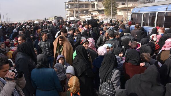 Syrians that evacuated the eastern districts of Aleppo gather to board buses, in a government held area in Aleppo, Syria in this handout picture provided by SANA on November - Sputnik Mundo