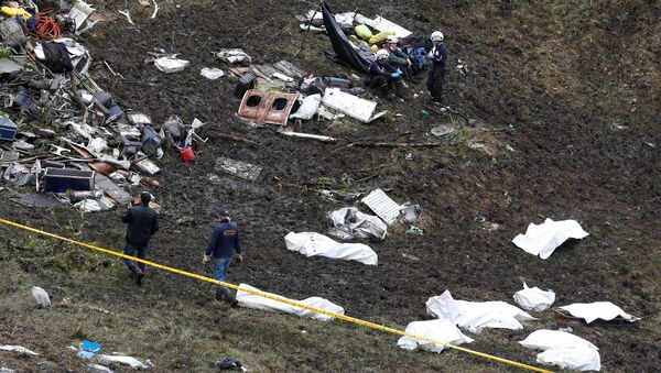 Rescue workers walk next to bodies from the wreckage of a plane that crashed into the Colombian jungle with the Brazilian soccer team Chapecoense onboard near Medellin, Colombia - Sputnik Mundo