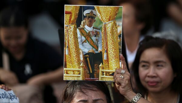 Una mujer con el retrato del nuevo rey de Tailandia - Sputnik Mundo