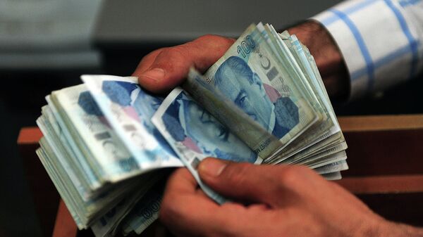 An exchange office worker counts Turkish lira banknotes in Istanbul on June 8, 2015 - Sputnik Mundo