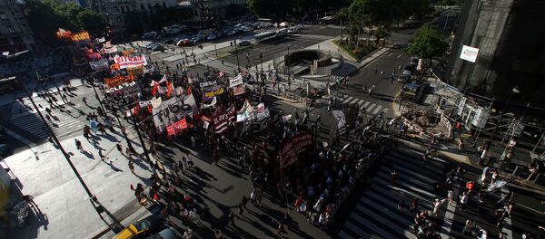 Demonstrators cross 9 de Julio Avenue as they march against Argentine President Mauricio Macri's administration and to mark the 15th anniversary of economic crisis that led to the fall of former president Fernando de la Rua, in Buenos Aires, Argentina Demonstrators cross 9 de Julio Avenue as they march against Argentine President Mauricio Macri's administration and to mark the 15th anniversary of economic crisis that led to the fall of former president Fernando de la Rua, in Buenos Aires, Argentina - Sputnik Mundo