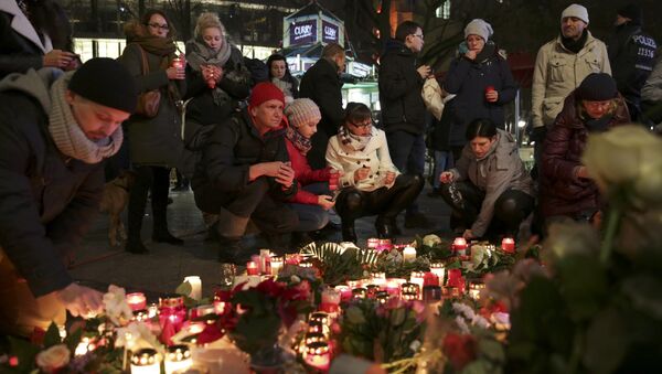 Candles burn at a Christmas market in Berlin, - Sputnik Mundo