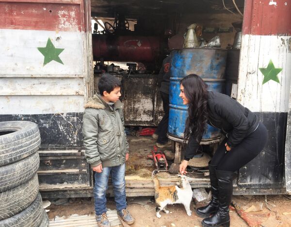 La cineasta boliviana Carla Ortiz junto a un niño en Siria La cineasta boliviana Carla Ortiz junto a un niño en Siria - Sputnik Mundo