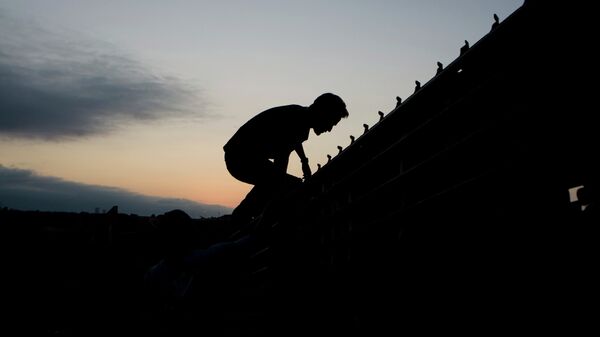 Un migrante salta para cruzar la valla fronteriza de Estados Unidos en Tijuana, México, 2008 - Sputnik Mundo