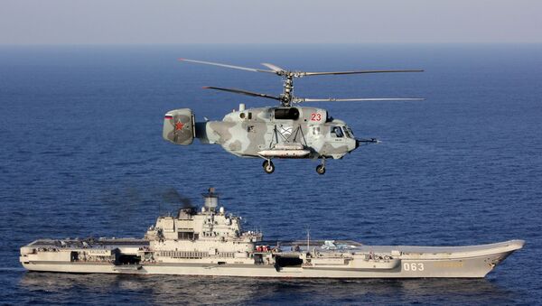 Un Ka-29, con el Almirante Kuznetsov de fondo, en el Mediterráneo - Sputnik Mundo