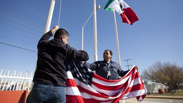 In this Friday, Dec. 27, 2013 photo, workers at one of maquiladoras of the TECMA group prepare to raise the U.S. flag along with the Mexican and TECMA flags in Ciudad Juarez, Mexico - Sputnik Mundo