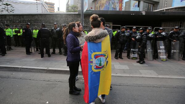 A woman wrapped in a national flag stands outside the electoral council (CNE) headquarters as leftist government candidate Lenin Moreno was set for victory but results still coming in meant he may face a runoff with CREO candidate Guillermo Lasso, in Quito - Sputnik Mundo