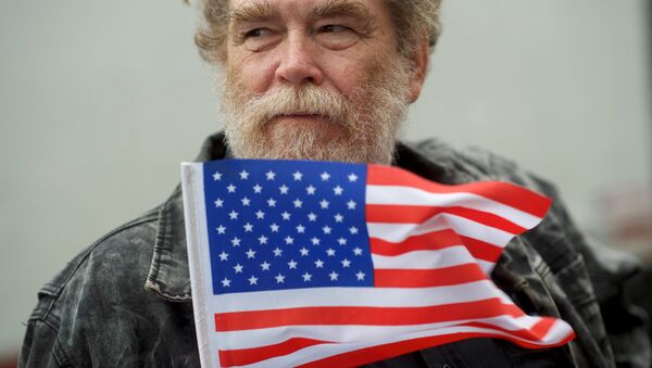 Un hombre con la bandera de EEUU - Sputnik Mundo