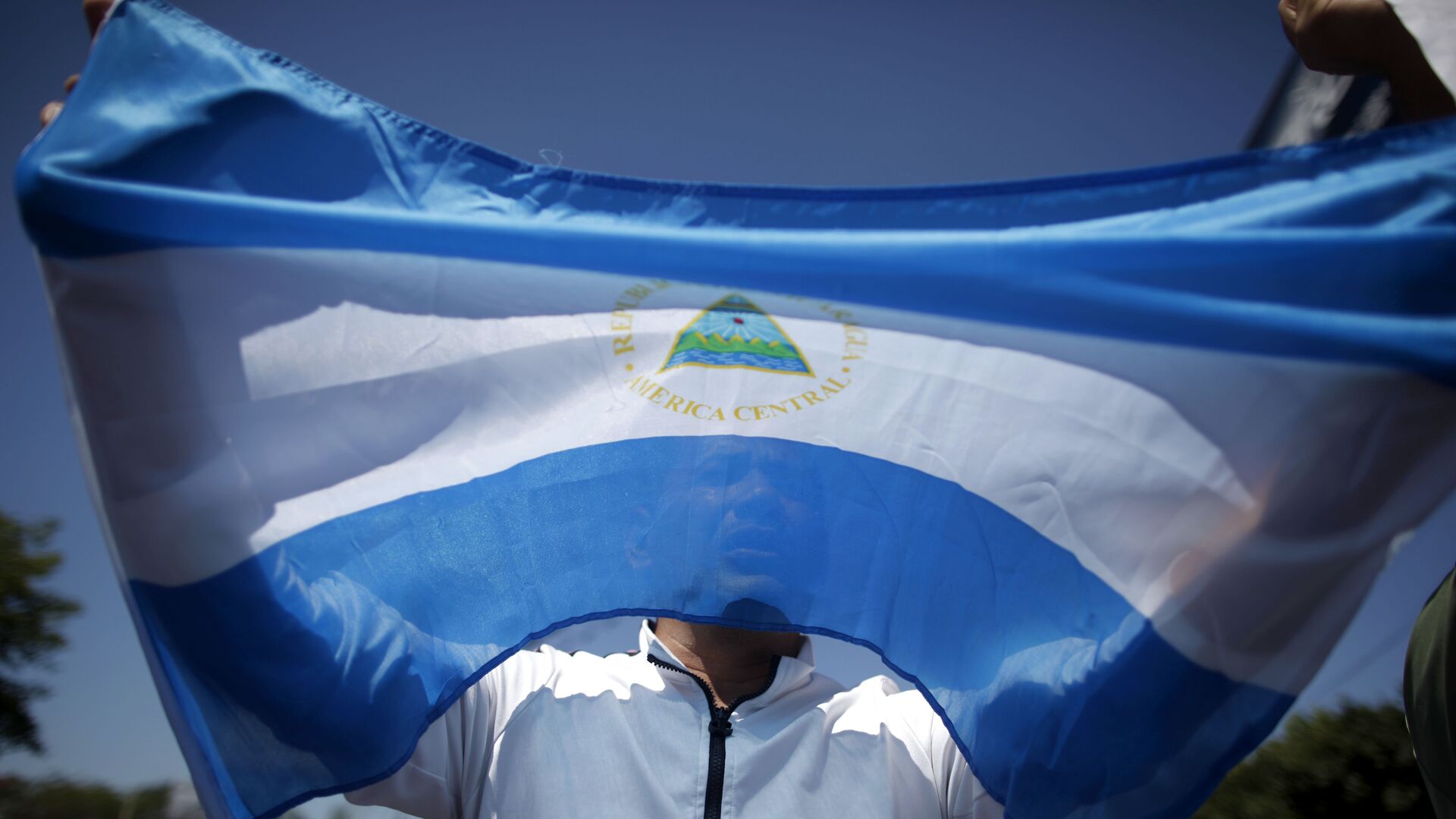 A man holds up a Nicaraguan flag during a demonstration against the presidential candidacy of Nicaragua's President Daniel Ortega in Managua, Nicaragua, Sunday, Feb 20, 2011.  - Sputnik Mundo, 1920, 06.12.2021