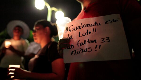 A man holds a banner that reads Guatemala is in mourning. we are missing 33 girls during a vigil for victims of a fire at the Virgen de Asuncion home in Guatemala, in Managua, Nicaragua - Sputnik Mundo