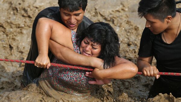 Una mujer es rescatada durante las lluvias que azotaron Huachipa, Perú (archivo) - Sputnik Mundo